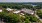 Aerial view of a historic brick mill building surrounded by trees, with solar panels on the rooftop.