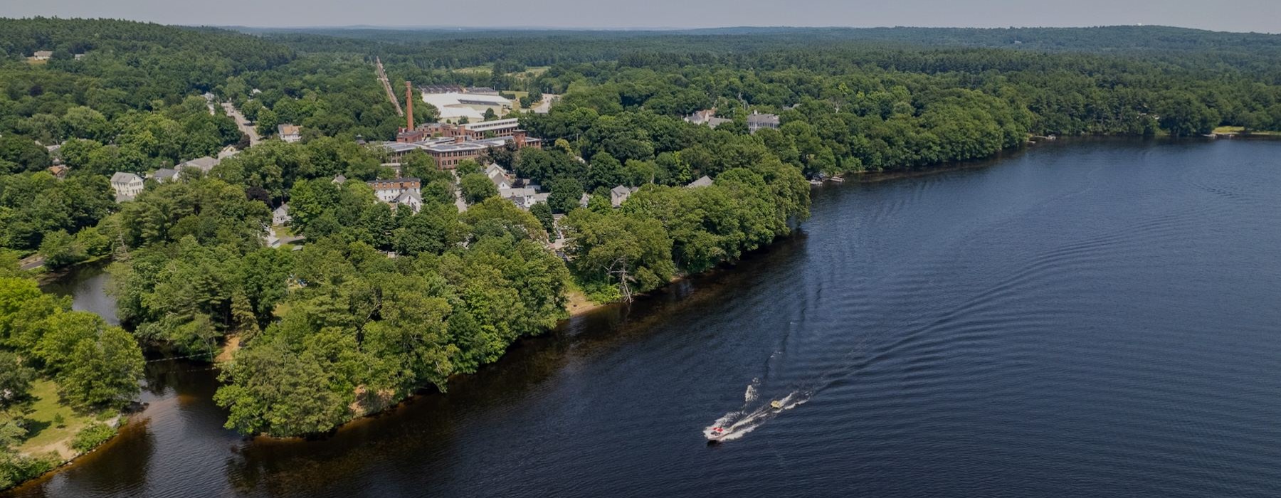 a large body of water with a boat on it and many trees