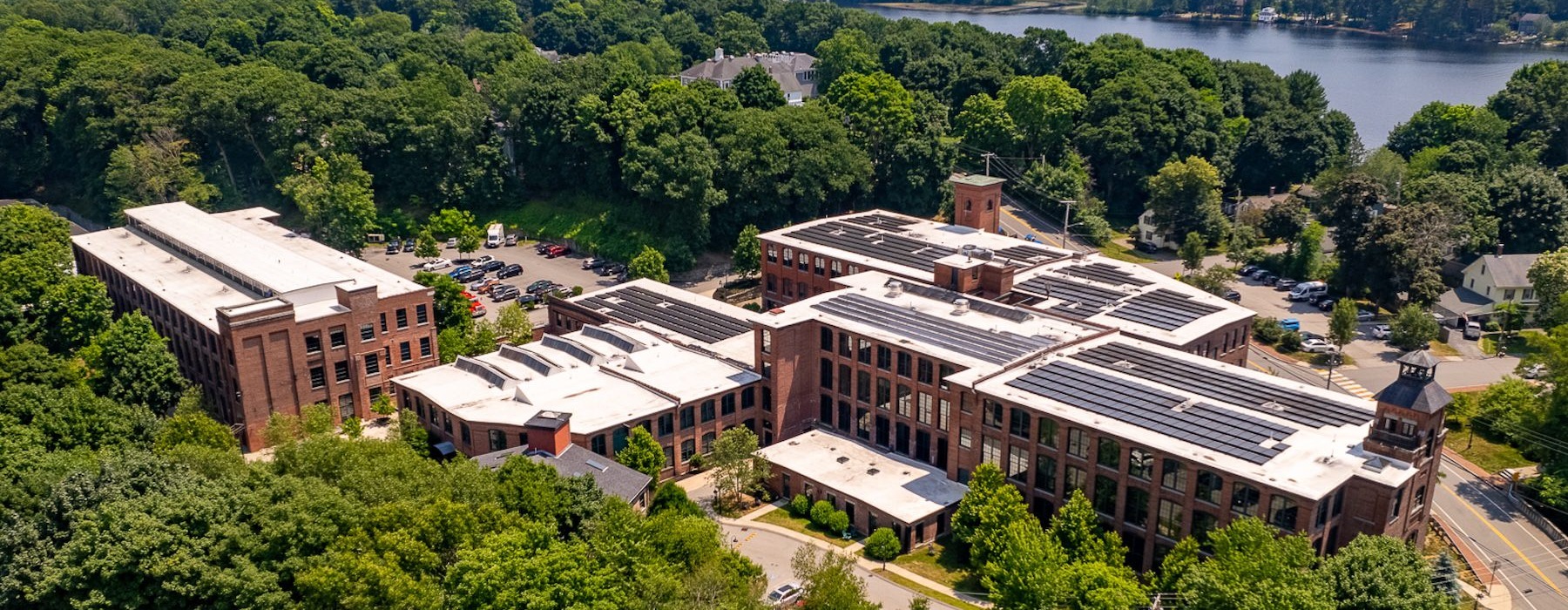 aerial view of building with trees and a body of water