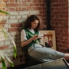 a person sitting in a corner looking at a phone